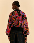 back view of model wearing colorful wild horse sweater with beaded fringe detail