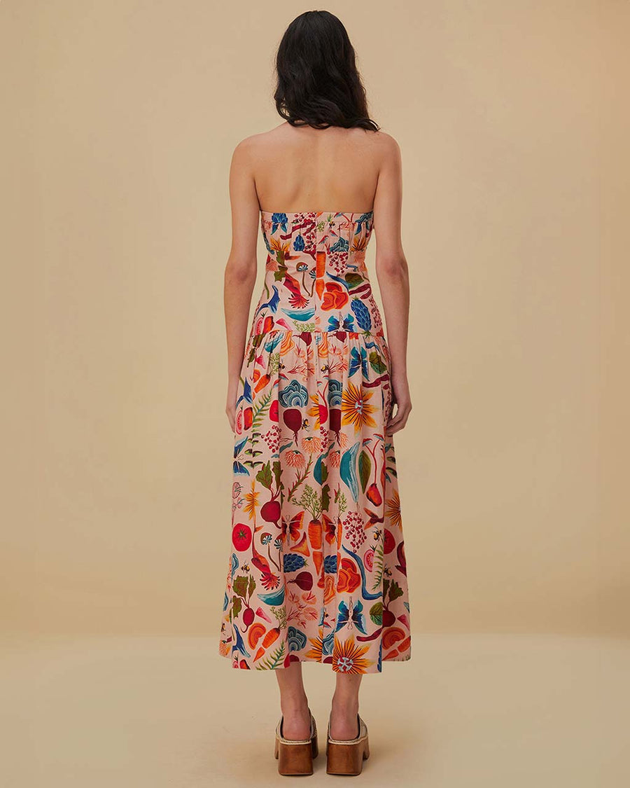 back view of model wearing cream strapless maxi dress with abstract floral print and gorgeous button front detail