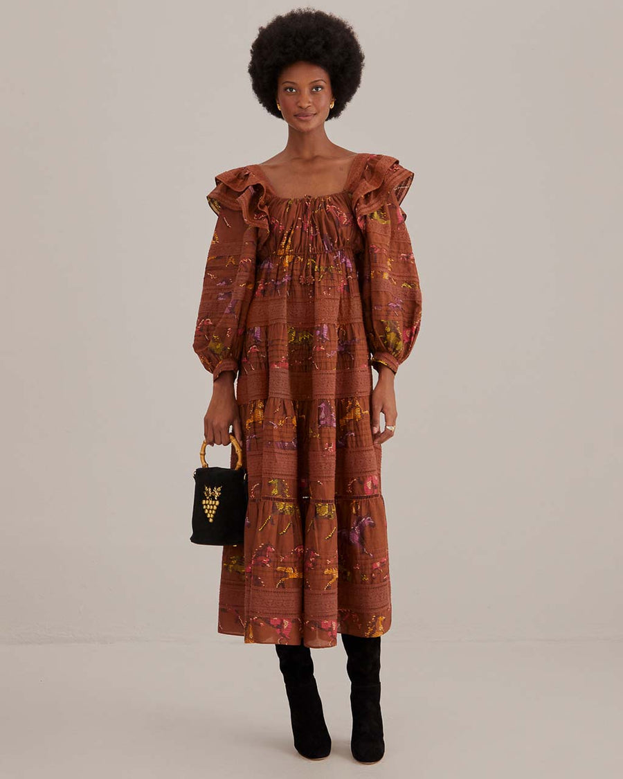 model wearing brown maxi dress with ruffle shoulders, puff sleeves and gorgeous colorful horse print