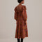 back view of model wearing brown maxi dress with ruffle shoulders, puff sleeves and gorgeous colorful horse print