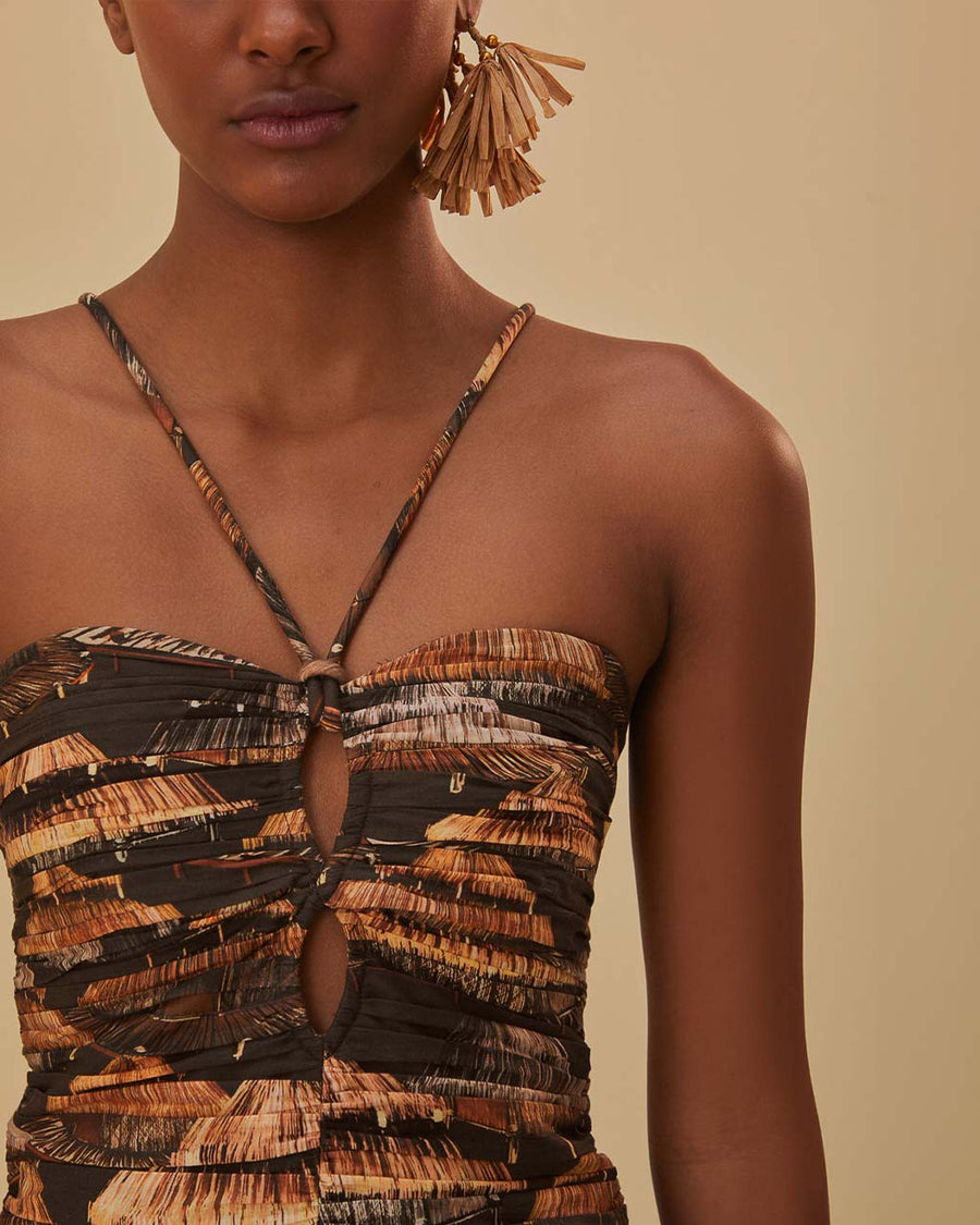 up close of model wearing brown maxi dress with cutout front, tie halter neckline and burnt orange fan print
