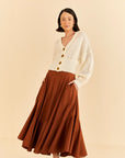 model wearing caramel color ruffle maxi skirt and white cardigan