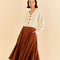 model wearing caramel color ruffle maxi skirt and white cardigan