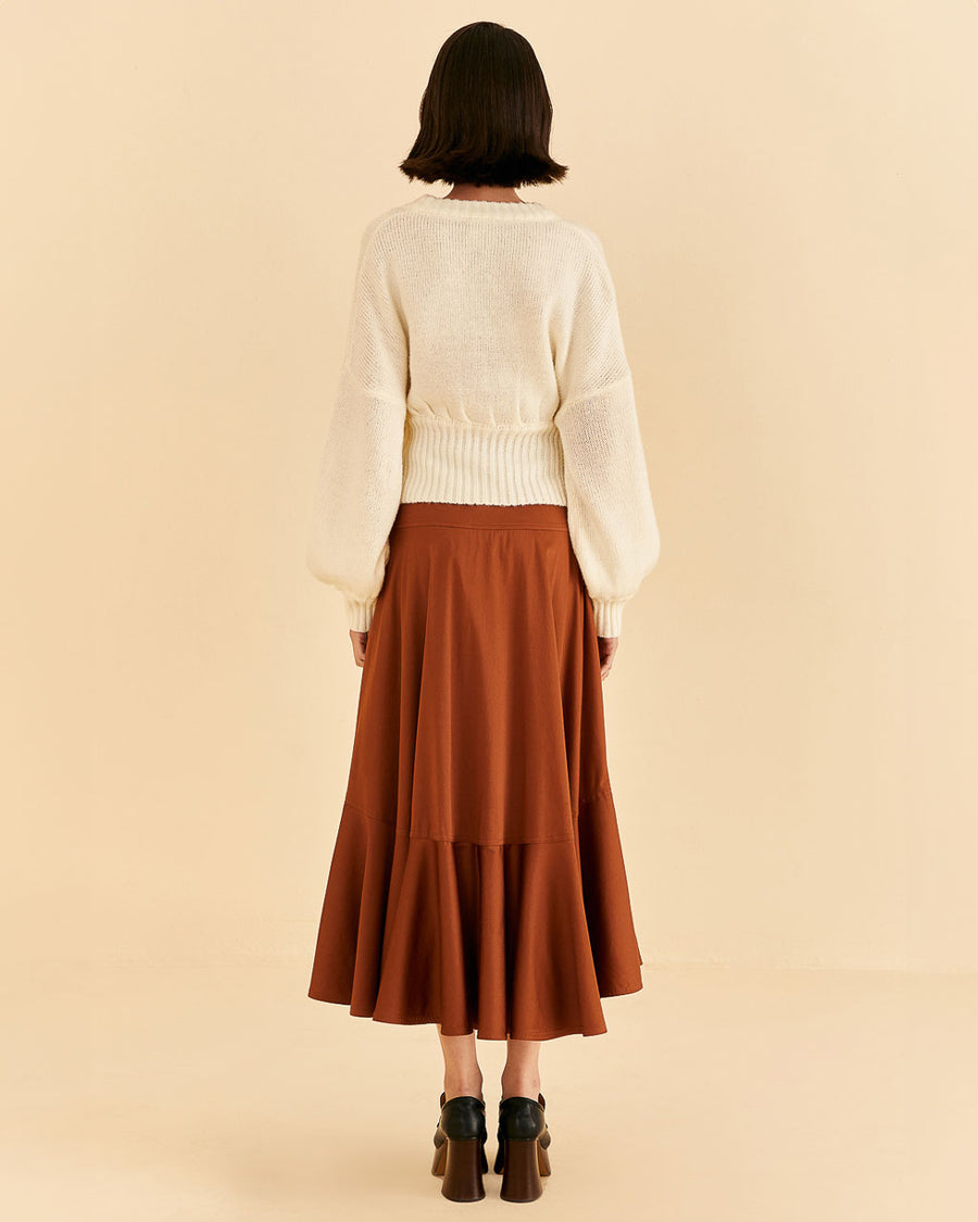 backview of model wearing caramel color ruffle maxi skirt and white cardigan