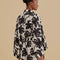 back view of model wearing black and white palm tree print shorts and matching kimono top