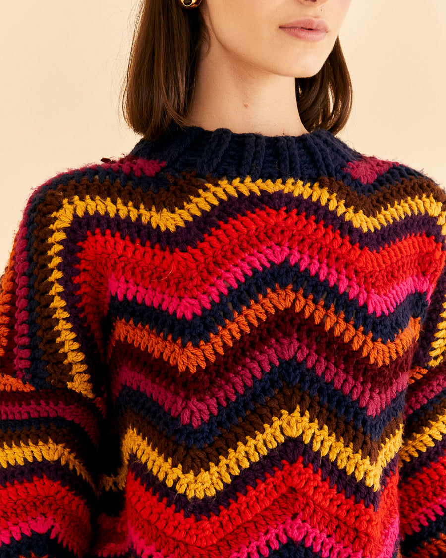 up close of model wearing colorful wavy stripe sweater with high neckline