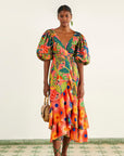 model wearing coral macaw print midi dress with puff sleeves, ruffle bottom and tie waist