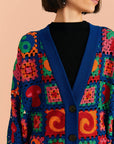 up close of navy blue patchwork cardi with mushroom, yin yang, swirls and patchwork designs