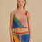 model wearing open crochet cropped tank with diagonal rainbow stripes and matching skirt