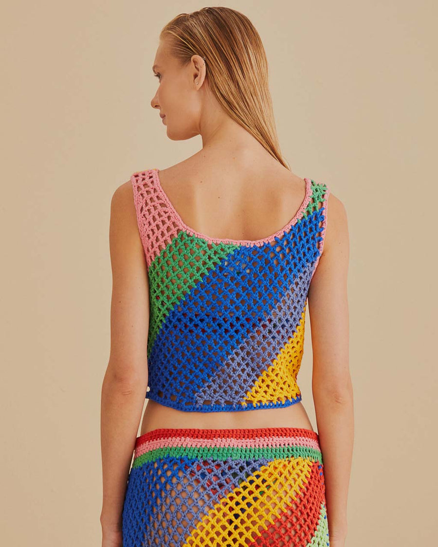 back view of model wearing open crochet cropped tank with diagonal rainbow stripes and matching skirt