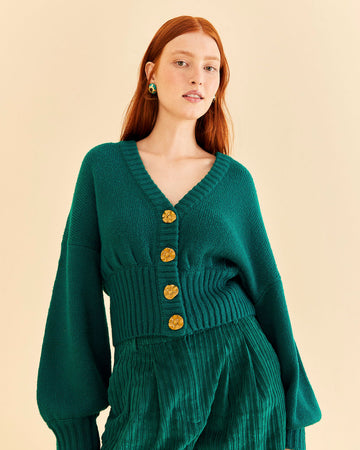 model wearing emerald cardigan with fun tan floral buttons, balloon sleeves and ribbed waist