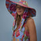 side view of model wearing multi floral floppy hat with long straps