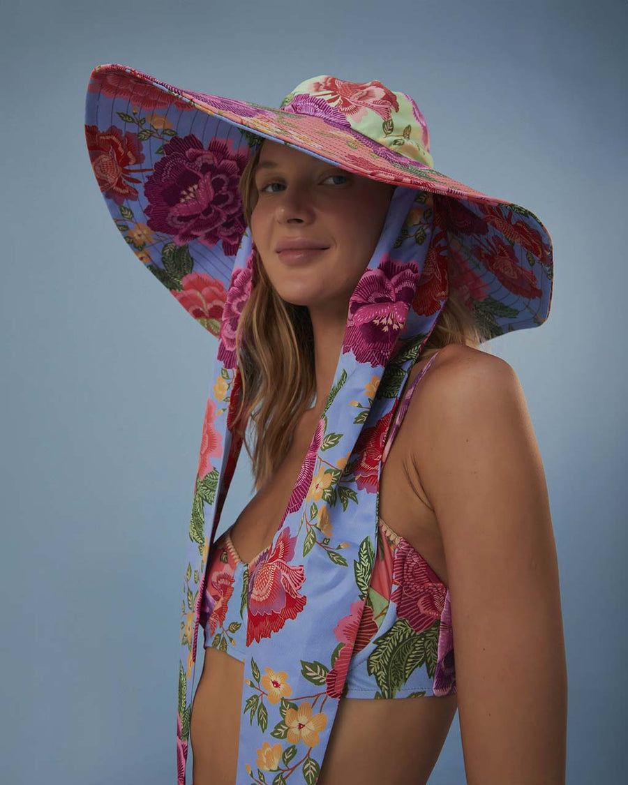 side view of model wearing multi floral floppy hat with long straps
