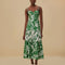 model wearing green and white patchwork midi dress with tropical leaf print and tiered skirt