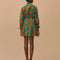 back view of model wearing teal mini dress with leopard print, beaded tassels, and flower applique