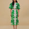 model wearing white midi skirt with green abstract floral print and wavy hems and matching blouse