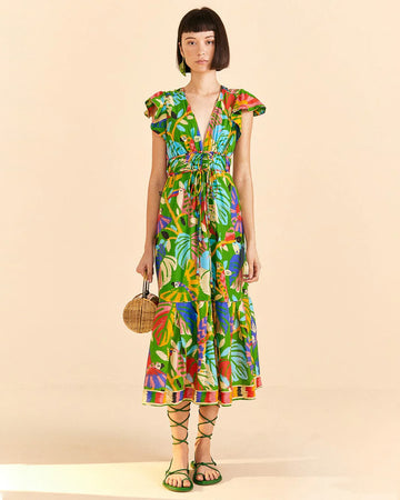 model wearing green midi dress with abstract toucan print, tie waist and slight flutter sleeves