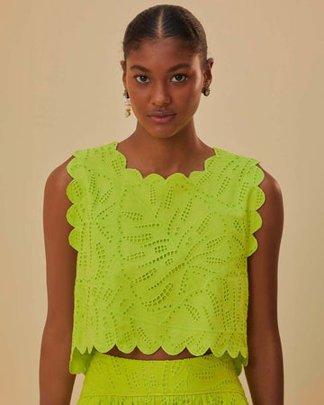model wearing lime green cropped tank with scalloped edges and eyelet detail
