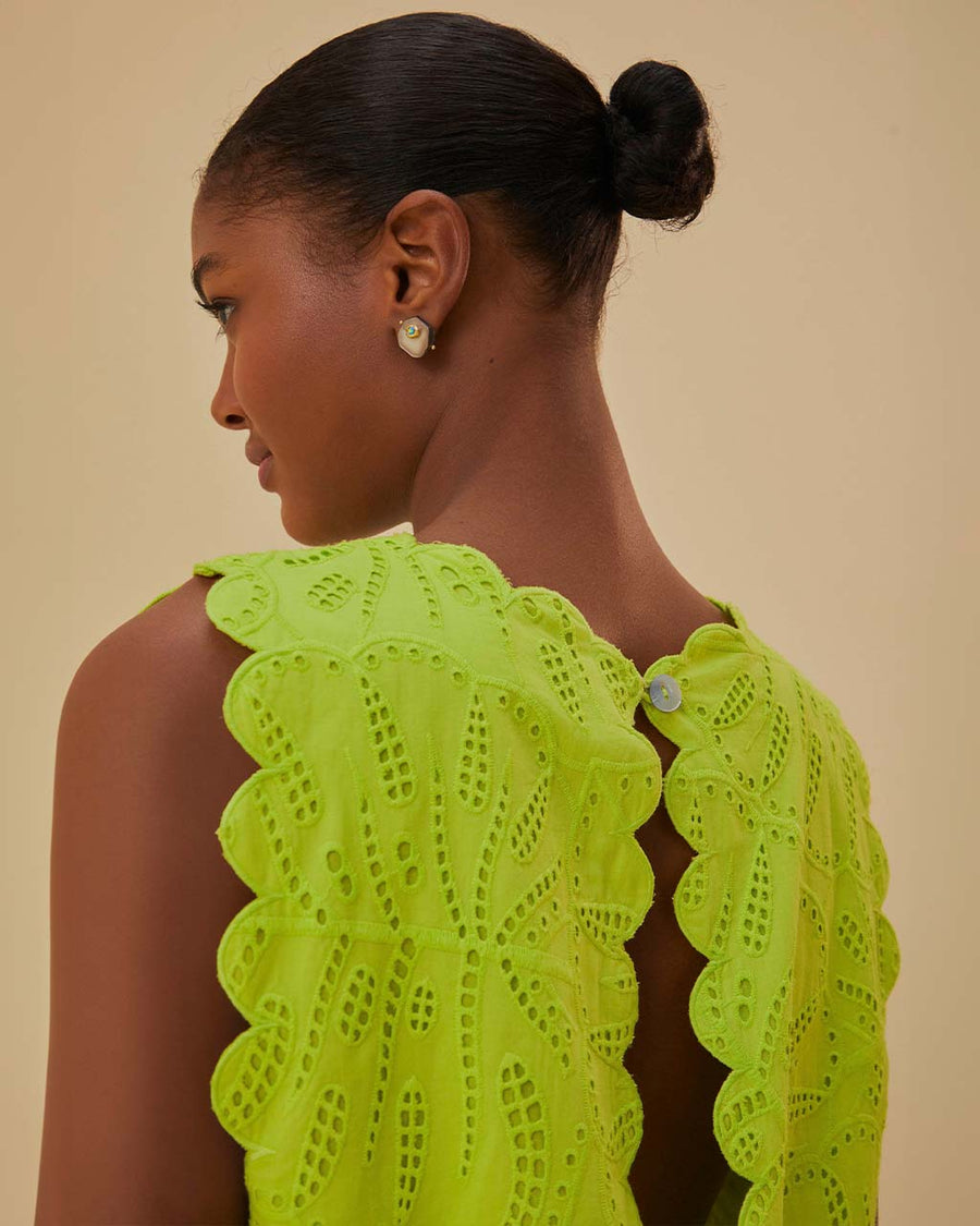 up close of model wearing lime green cropped tank with scalloped edges and eyelet detail