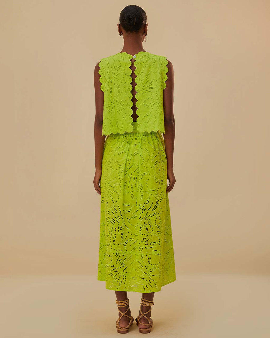back view of model wearing lime green eyelet maxi skirt with pockets