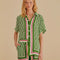 model wearing green short sleeve bottom down top with pineapple print and green, cream and red stripes down the center