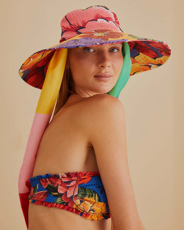 model wearing colorful bold floral floppy hat with thick side ties
