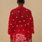 back view of model wearing red open knit crochet sweater with balloon sleeves, collar and small pink appliques