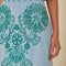 up close of model wearing light blue midi skirt with delicate green cut out pattern and matching top