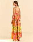 backview of model wearing brightly colored painted birds maxi dress with ric rac tiers and scalloped v neckline