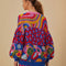 back view of model wearing relaxed fit cardigan with colorful waves, colorful leopard print and colorful abstract fruit print