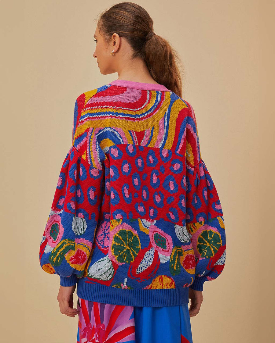 back view of model wearing relaxed fit cardigan with colorful waves, colorful leopard print and colorful abstract fruit print