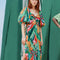 model wearing green colorful abstract midi dress with side slit and short puff sleeves