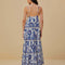 back view of model wearing white and blue maxi dress with abstract birds and flower print