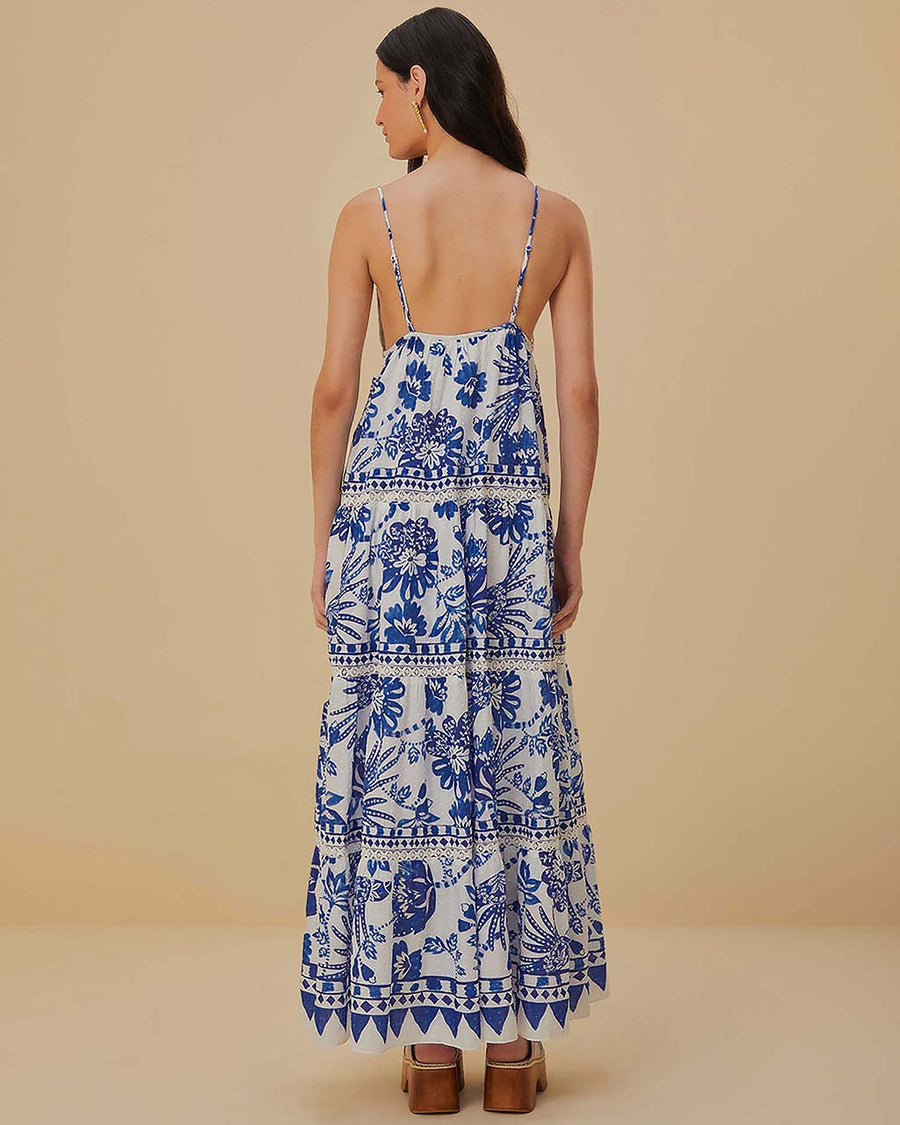 back view of model wearing white and blue maxi dress with abstract birds and flower print