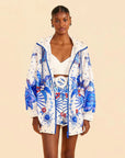 model wearing white relaxed fit jacket with blue abstract embroidered print