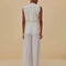 back view of model wearing white wide leg linen pants with gold belt detail