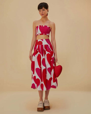 model wearing white midi skirt with painted red and pink hearts and smocked waistband