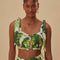 model wearing white cropped tank top with tie straps, ruffle detail and green tropical leaf print