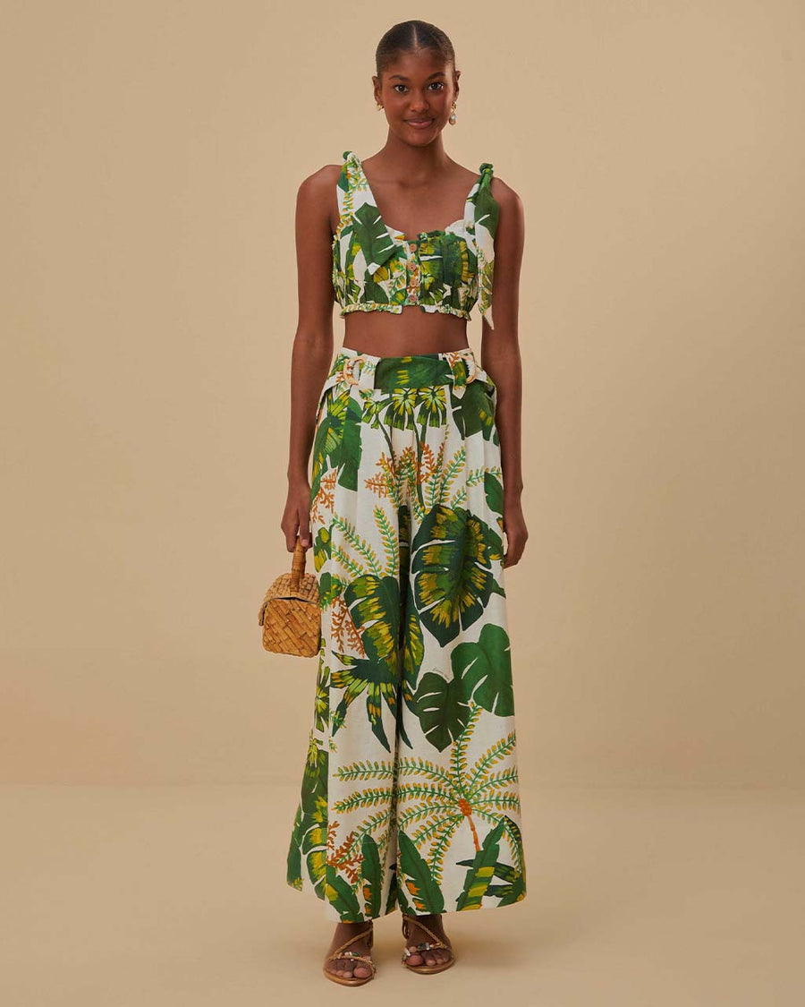 model wearing white wide leg pants with green tropical print