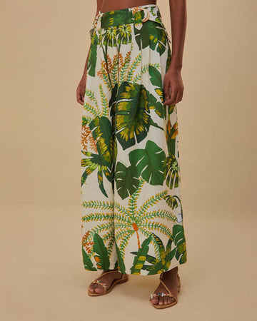 model wearing white wide leg pants with green tropical print