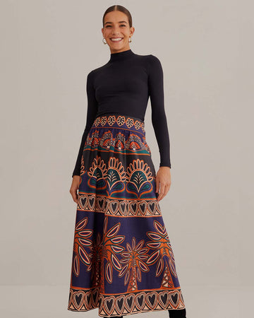 model wearing purple midi skirt with pops of teal, brown and orange abstract print