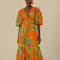 model wearing orange midi dress with puff sleeves, tie waist, deep V neckline and all over leaves and parrot print