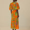 back view of model wearing orange midi dress with puff sleeves, tie waist, deep V neckline and all over leaves and parrot print
