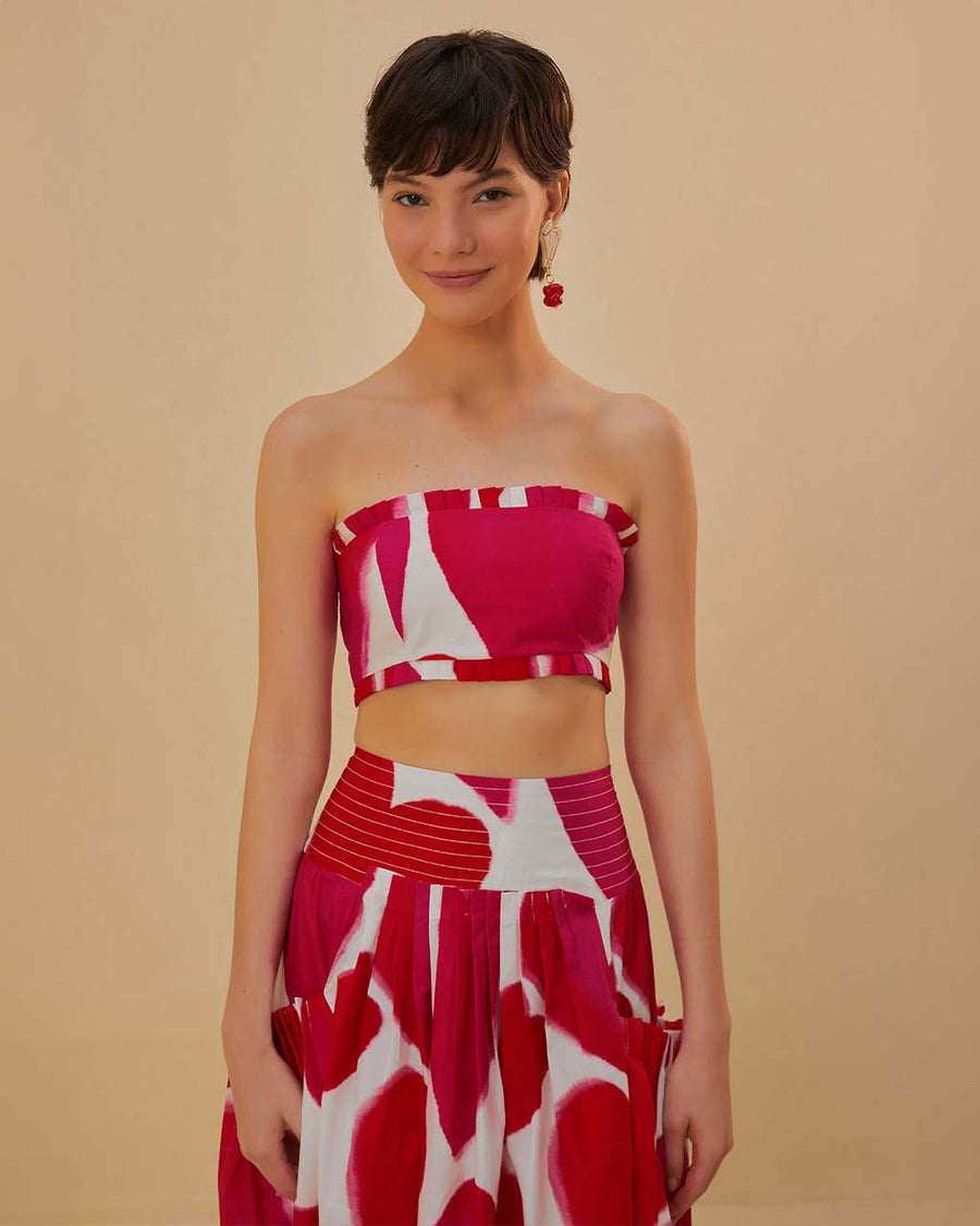 model wearing white cropped tube top with pink and red painted heart pattern