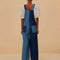 back view of model wearing light blue and dark blue overalls with patch front pockets