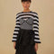 model wearing black and white striped crochet top with long, flared sleeves