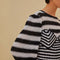 up close of model wearing black and white striped crochet top with long, flared sleeves