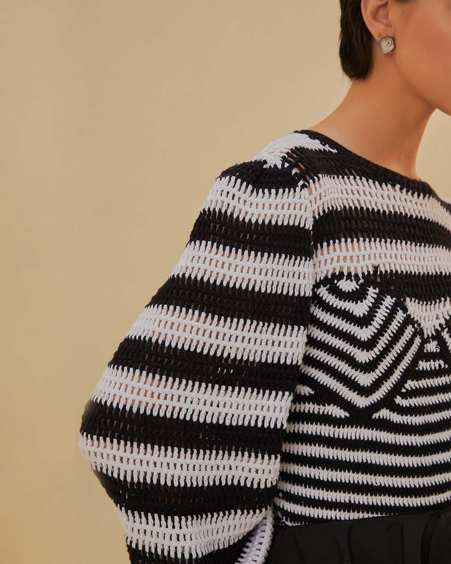 up close of model wearing black and white striped crochet top with long, flared sleeves