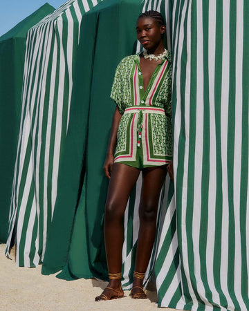 model wearing green shorts with beaded tassel tie, pineapple print and red, white and green stripes down the front