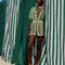 model wearing green shorts with beaded tassel tie, pineapple print and red, white and green stripes down the front